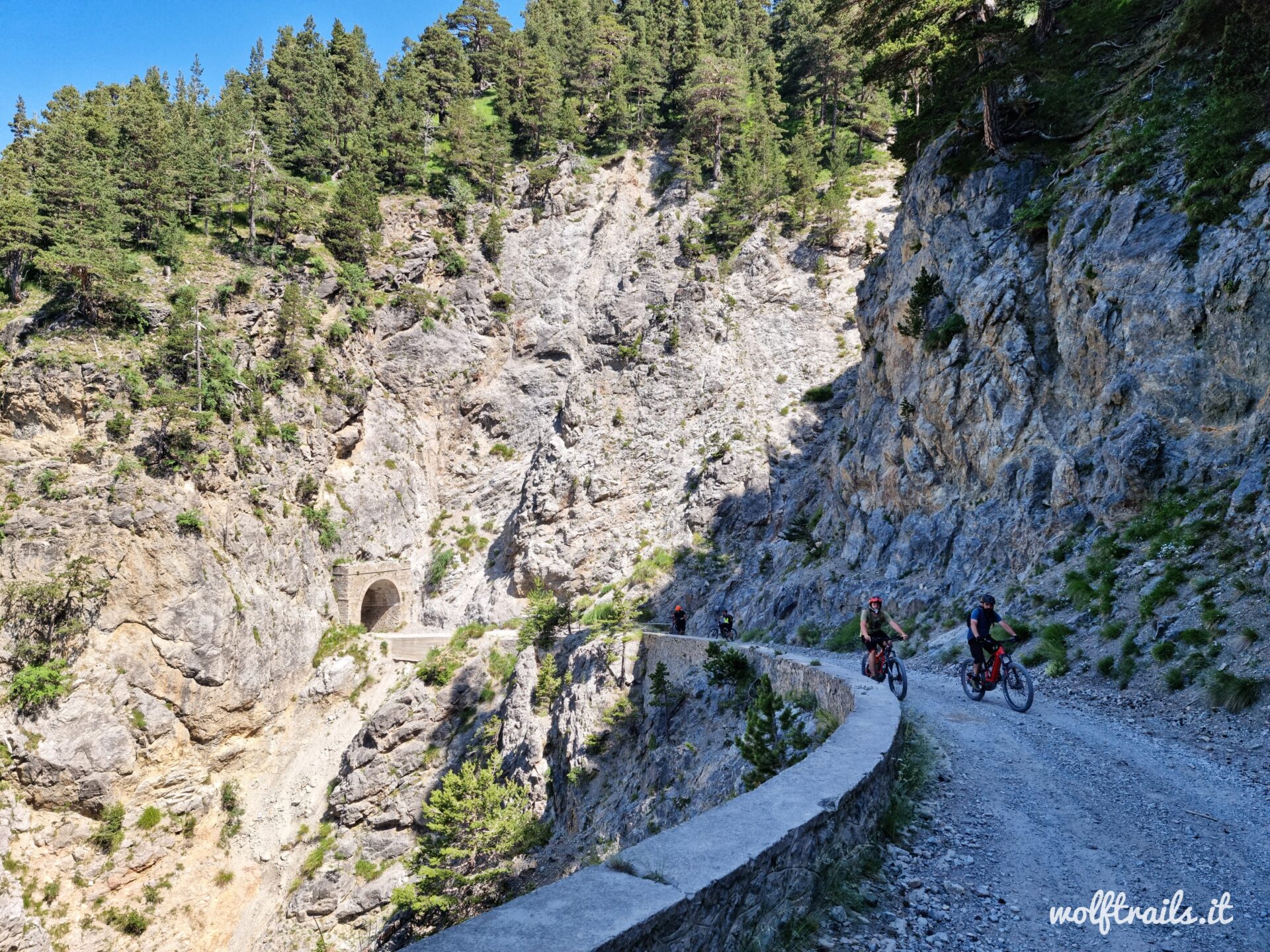 Mountain biker group riding an historical military road in the Western Alps