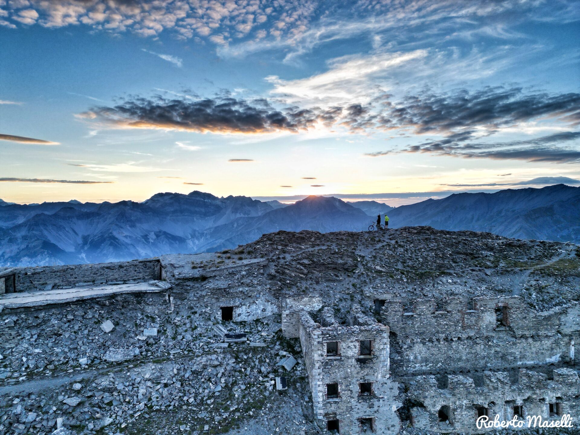 Mountainbikers on a high-altitude edge with military fort during Bardonecchia e-MTB tour