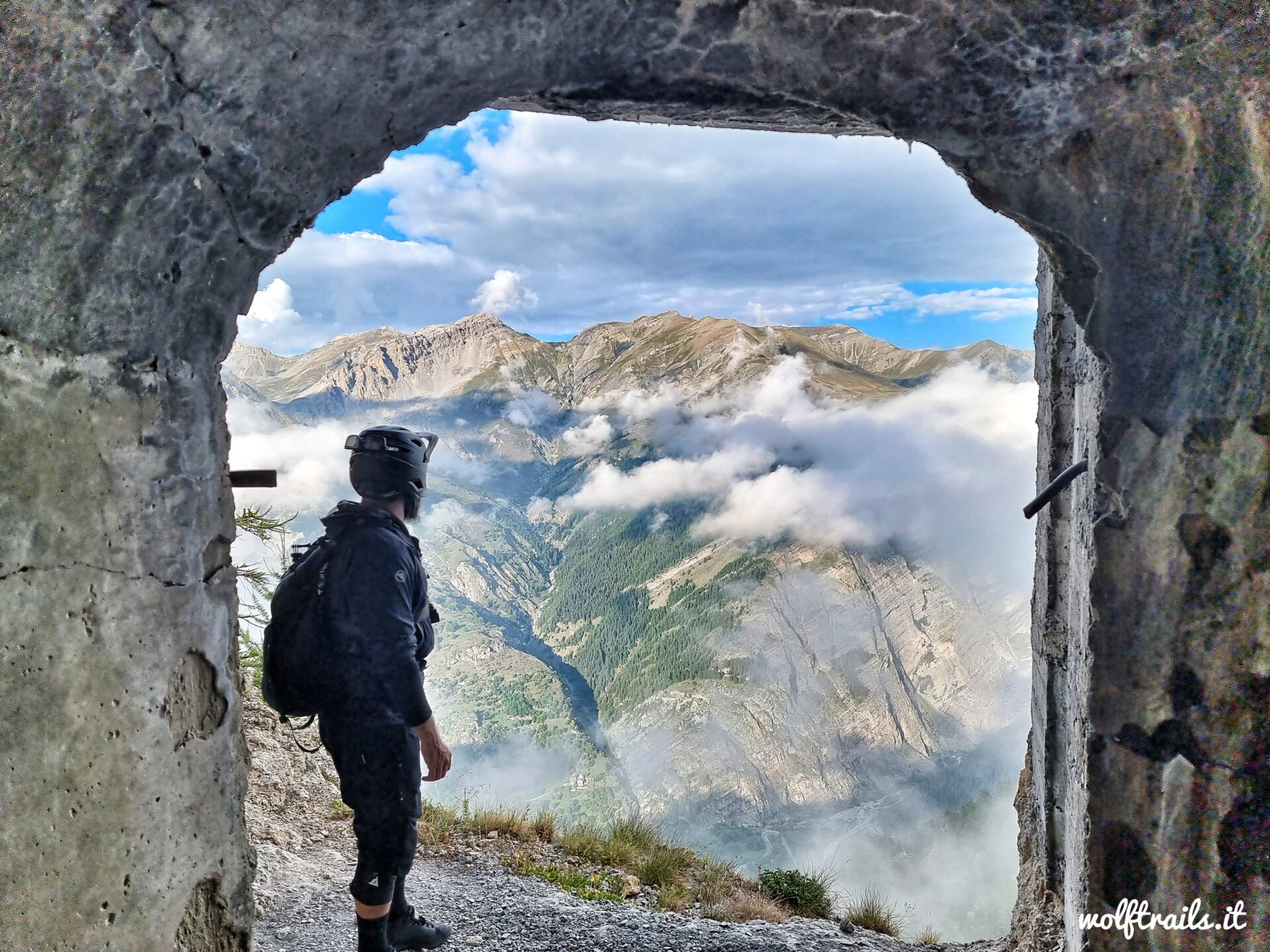 A Mountain Biker overlooking Valle Stura from an historical WW2 Bunker in the Italian Alps