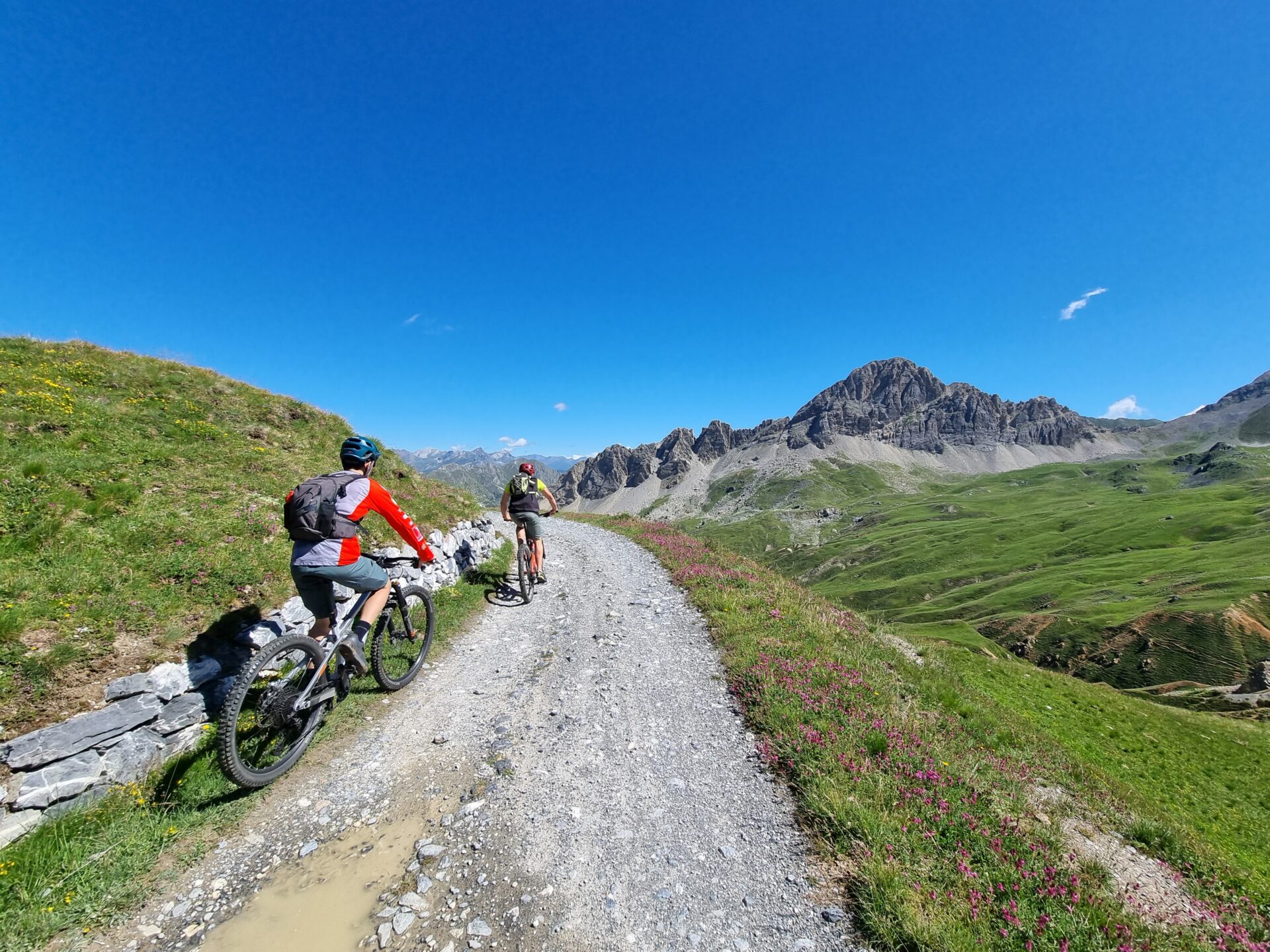 Mountain bikers riding the historic military road across the Gardetta Plateau in the Italian Alps