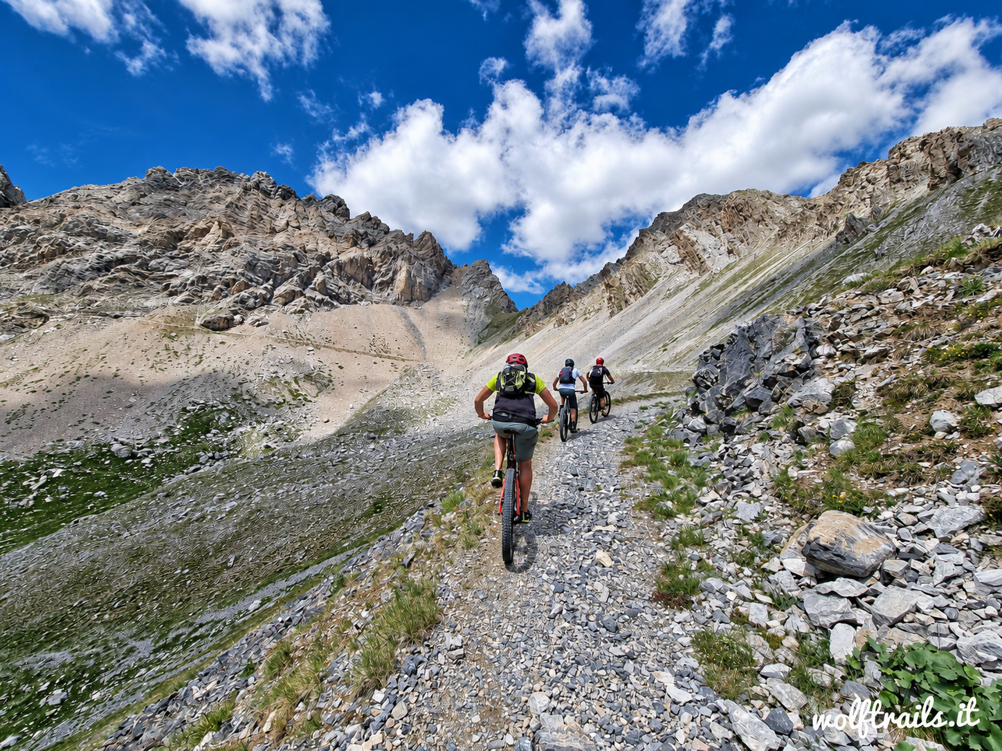 Mountain Bikers riding above Gardetta Plateau toward Stura Valley in the Western Alps